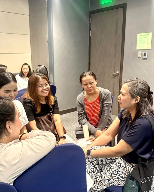 A small group of women sitting in a circle, talking